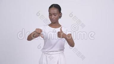 年轻漂亮的非洲女人在竖起大拇指和大拇指之间做出选择
